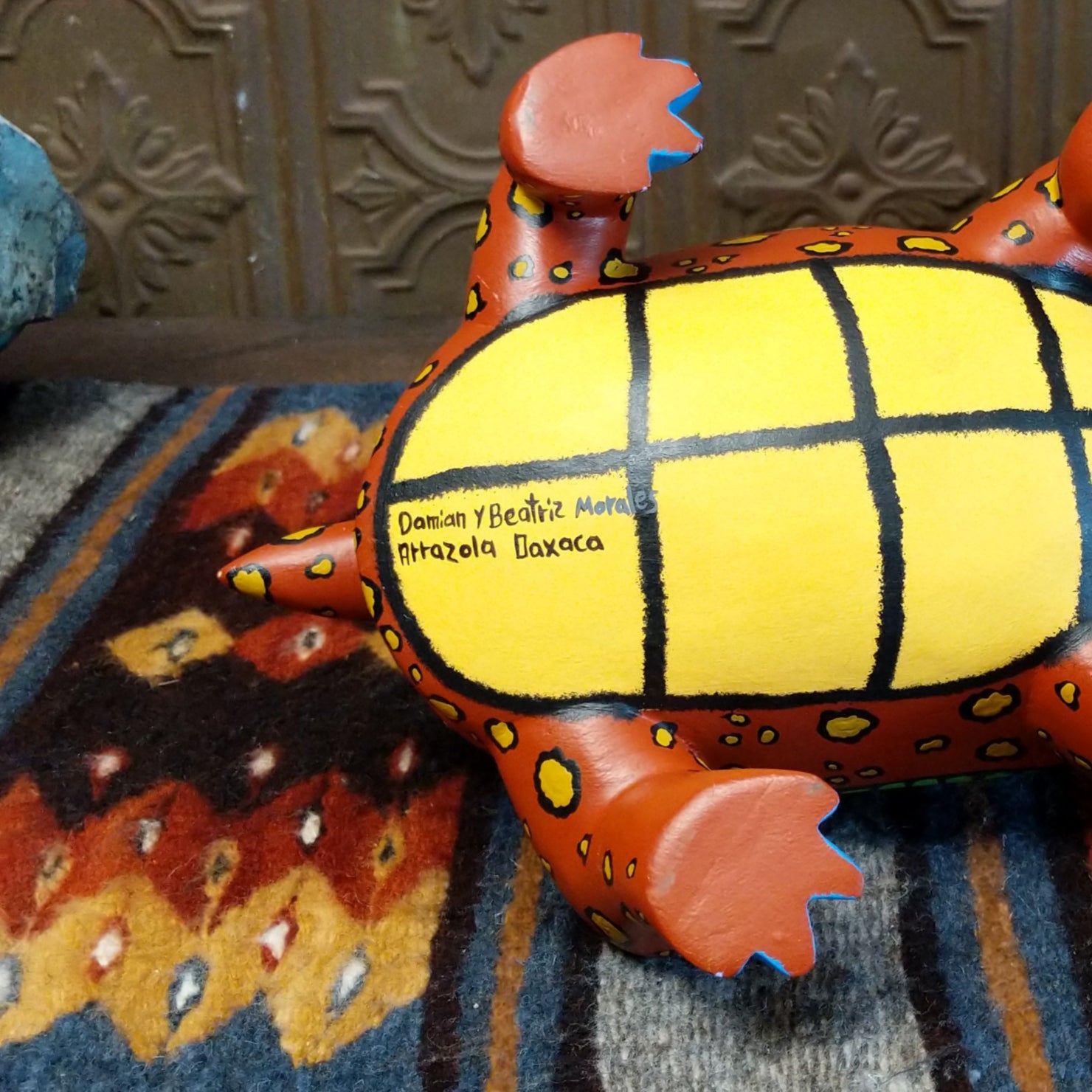 Artists signature on the yellow underbelly of the tortoise shell.