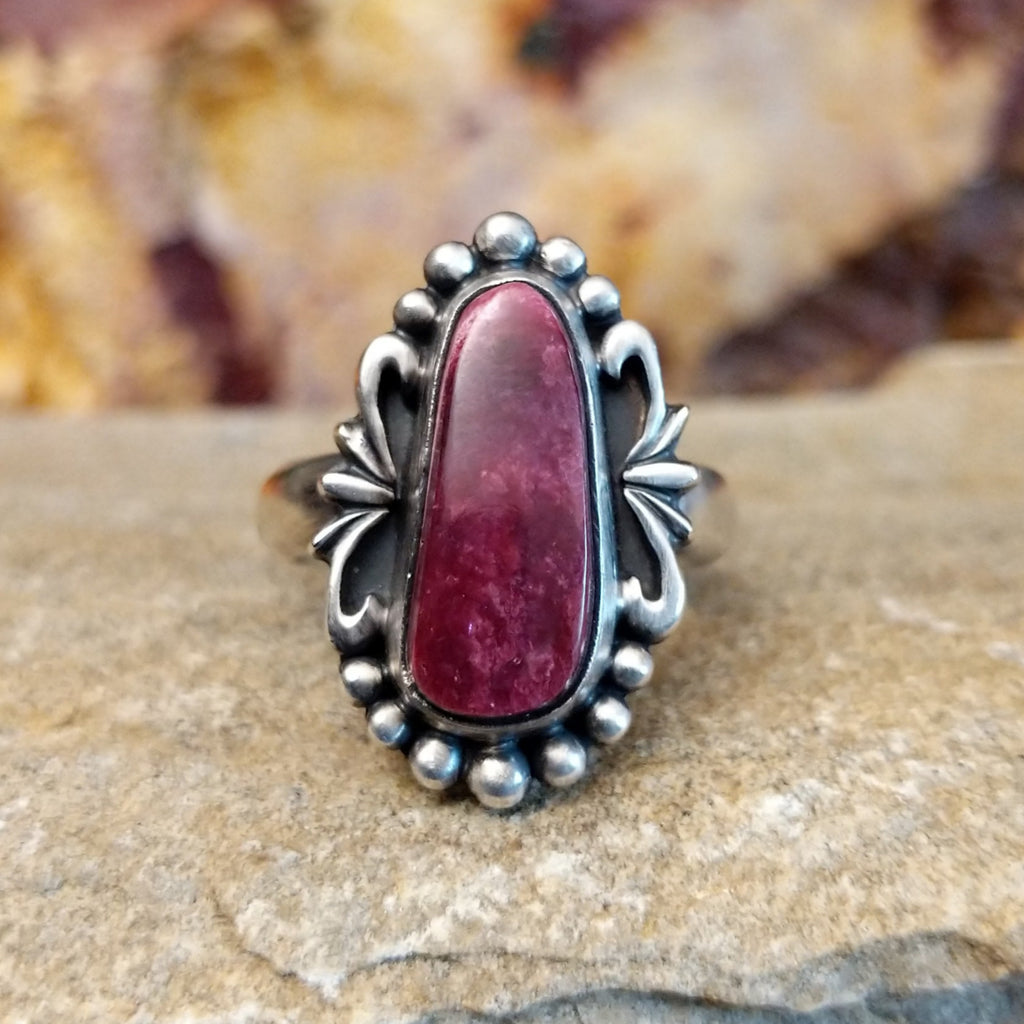 Oblong spiny oyster shell set in an sterling silver bezel with dotted accents and ornate silver-work.