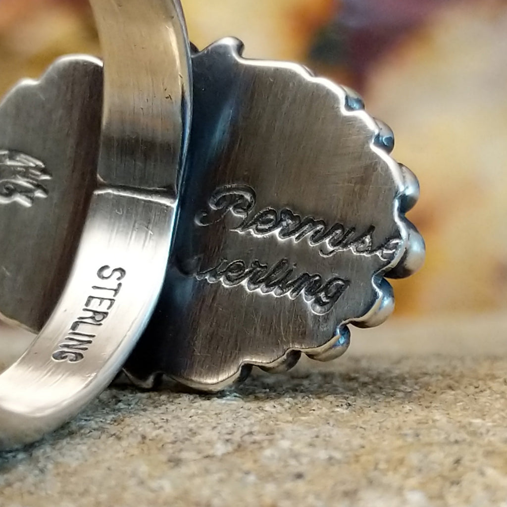 The artisan's signature and stamp is found on the underside of the bezel and band.