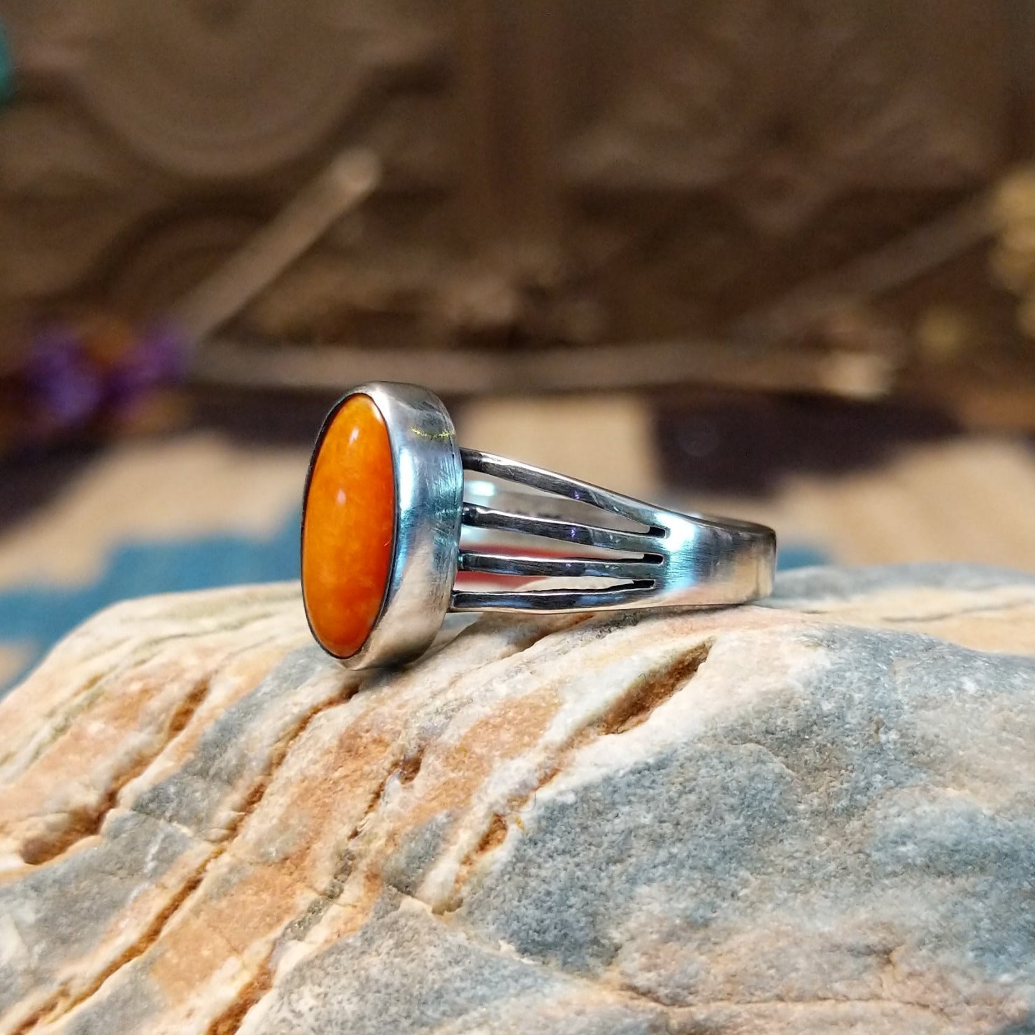 Sterling silver ring with orange spiny oyster shell set in an oval bezel and layered band.