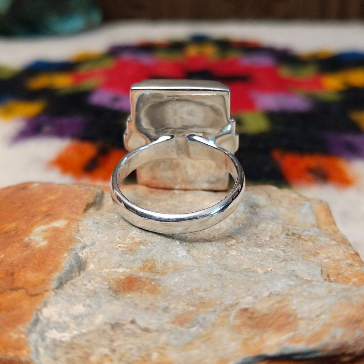 Orange spiny oyster shell inlay ring by Raymond Coriz with a central opal strip and rectangular silver setting.