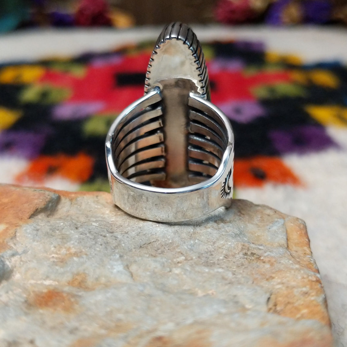 Orange Spiny Oyster Shell Navette Ring by Bernyse Chavez with an elongated orange and red shell cabochon, detailed sterling silver bezel, and wide split-style band; underside view.