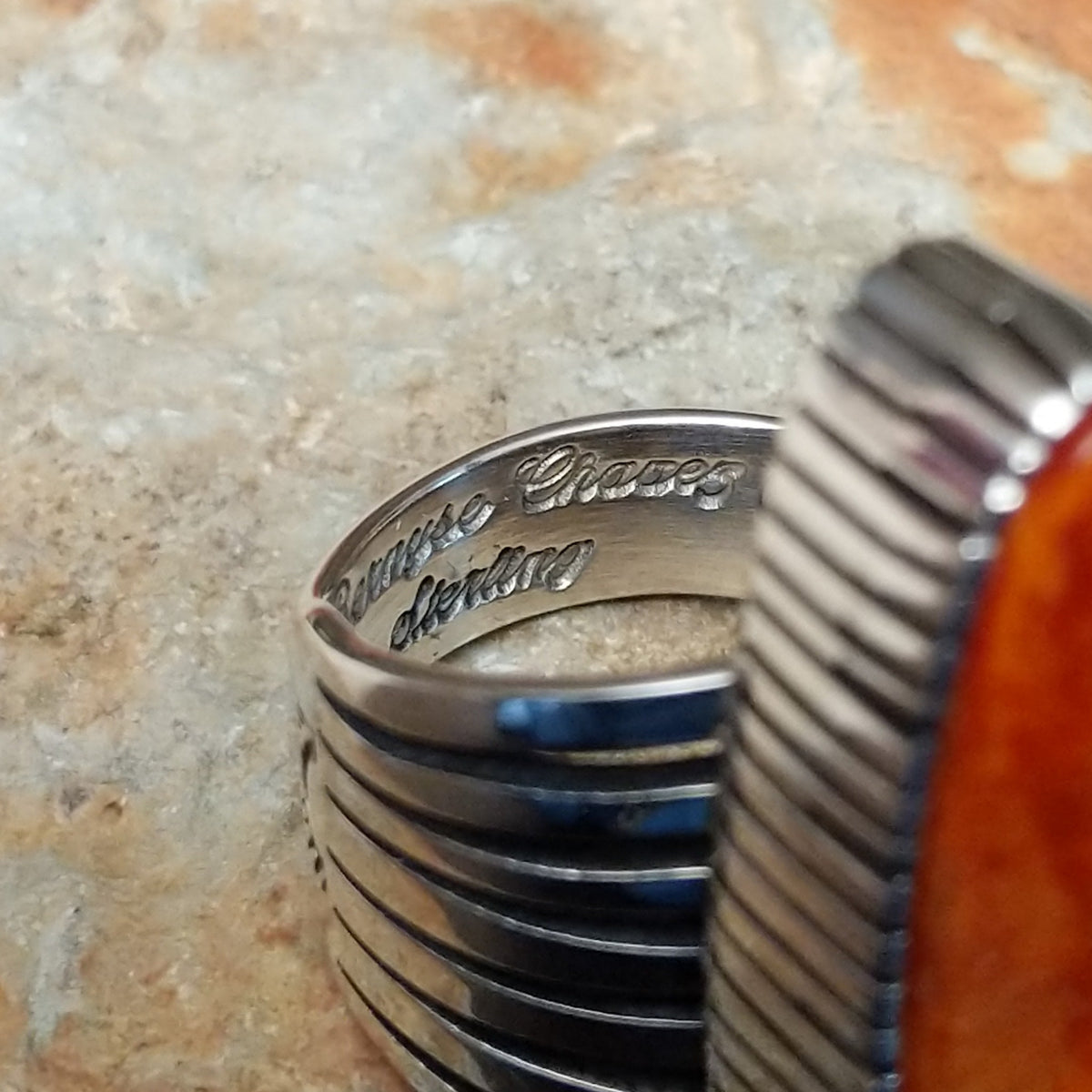 Orange Spiny Oyster Shell Navette Ring by Bernyse Chavez with an elongated orange and red shell cabochon, detailed sterling silver bezel, and wide split-style band; artisan and Sterling Silver stamp.