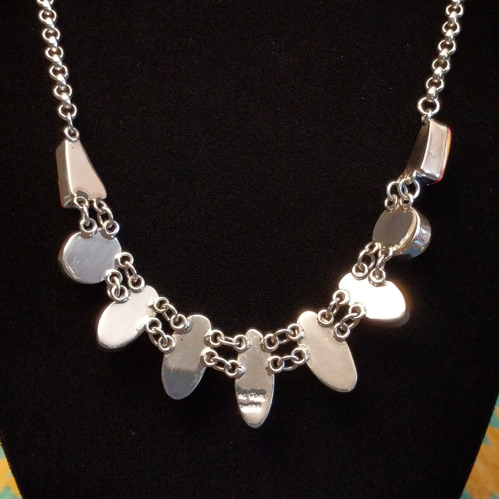 The back features the polished sterling silver bezels and chain.
