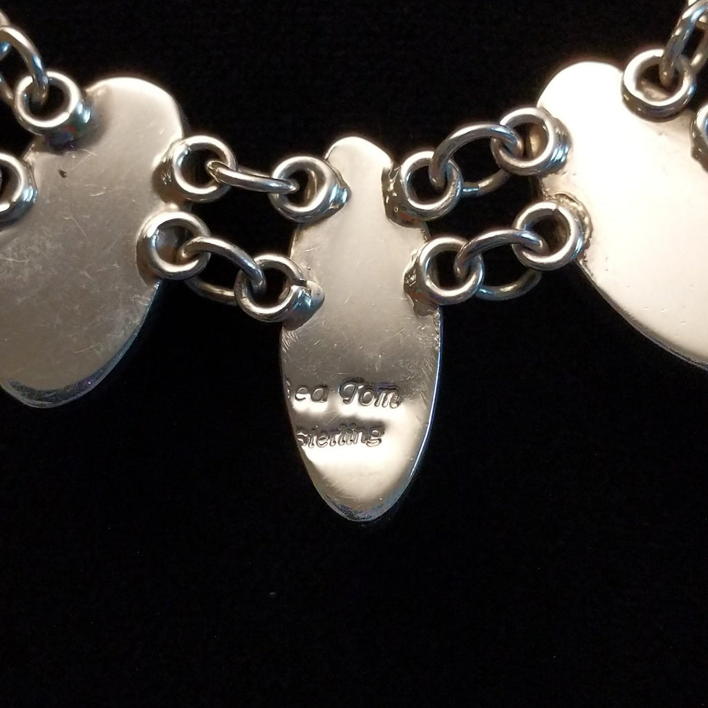 The artisan's signature is found on the back of the pendant.