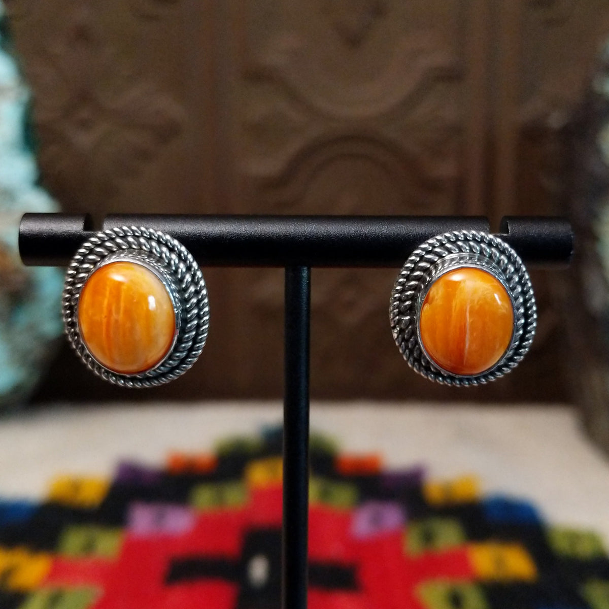 Orange Spiny Oyster Shell Oval Earrings by Priscilla Smith featuring vivid orange oval shell cabochons with natural golden variations, set in silver with layered twisted rope-style borders.