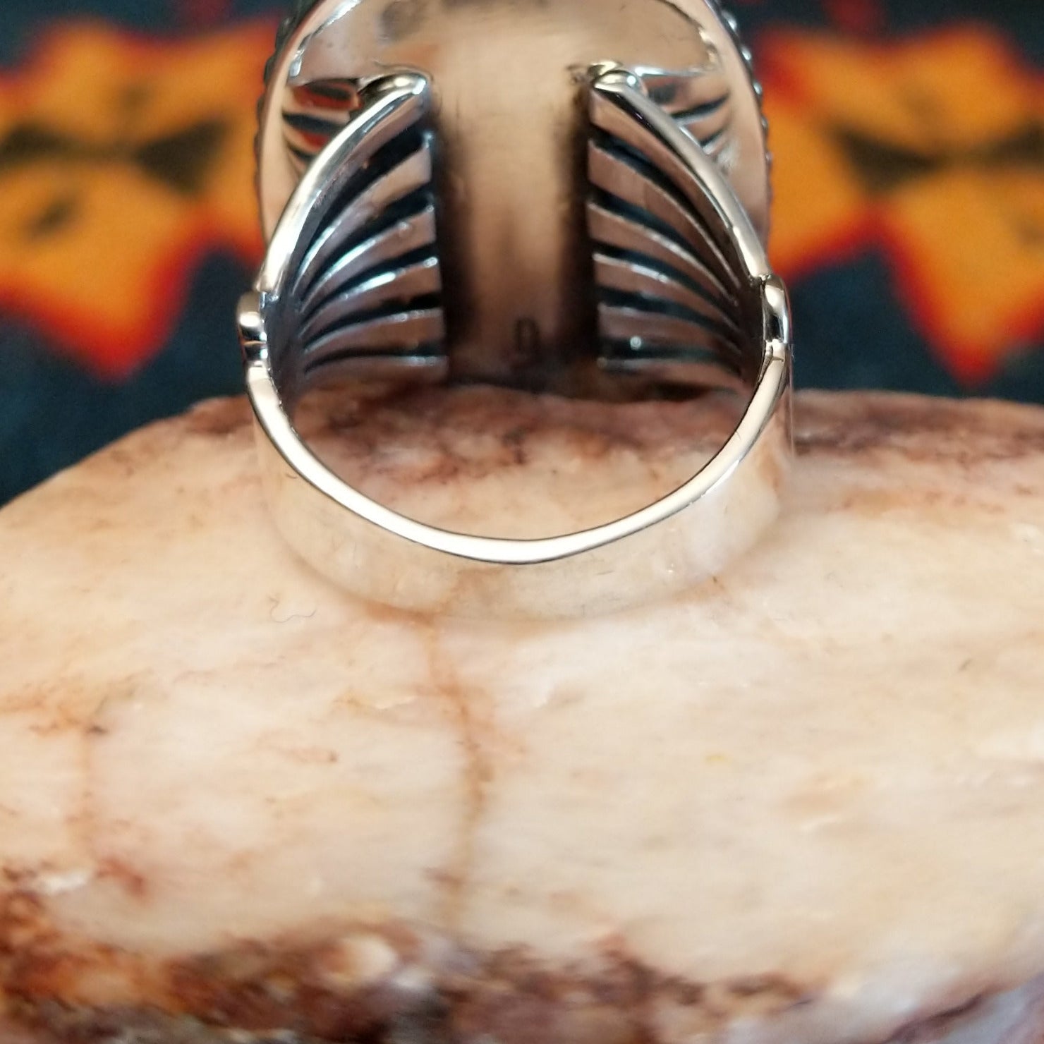Sterling silver ring with oval orange spiny oyster shell set in the bezel, framed by twisted rope and dotted accents.
