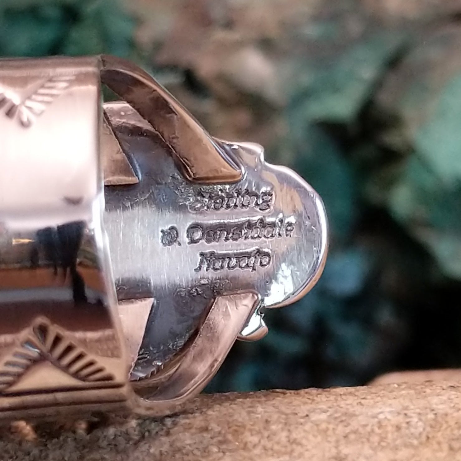The signature stamped into the underside of the bezel.