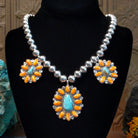 The necklace has a sterling silver beaded chain with three cluster pendants, each with turquoise and orange spiny oyster shell on the bezels with twisted silver rope detailing.