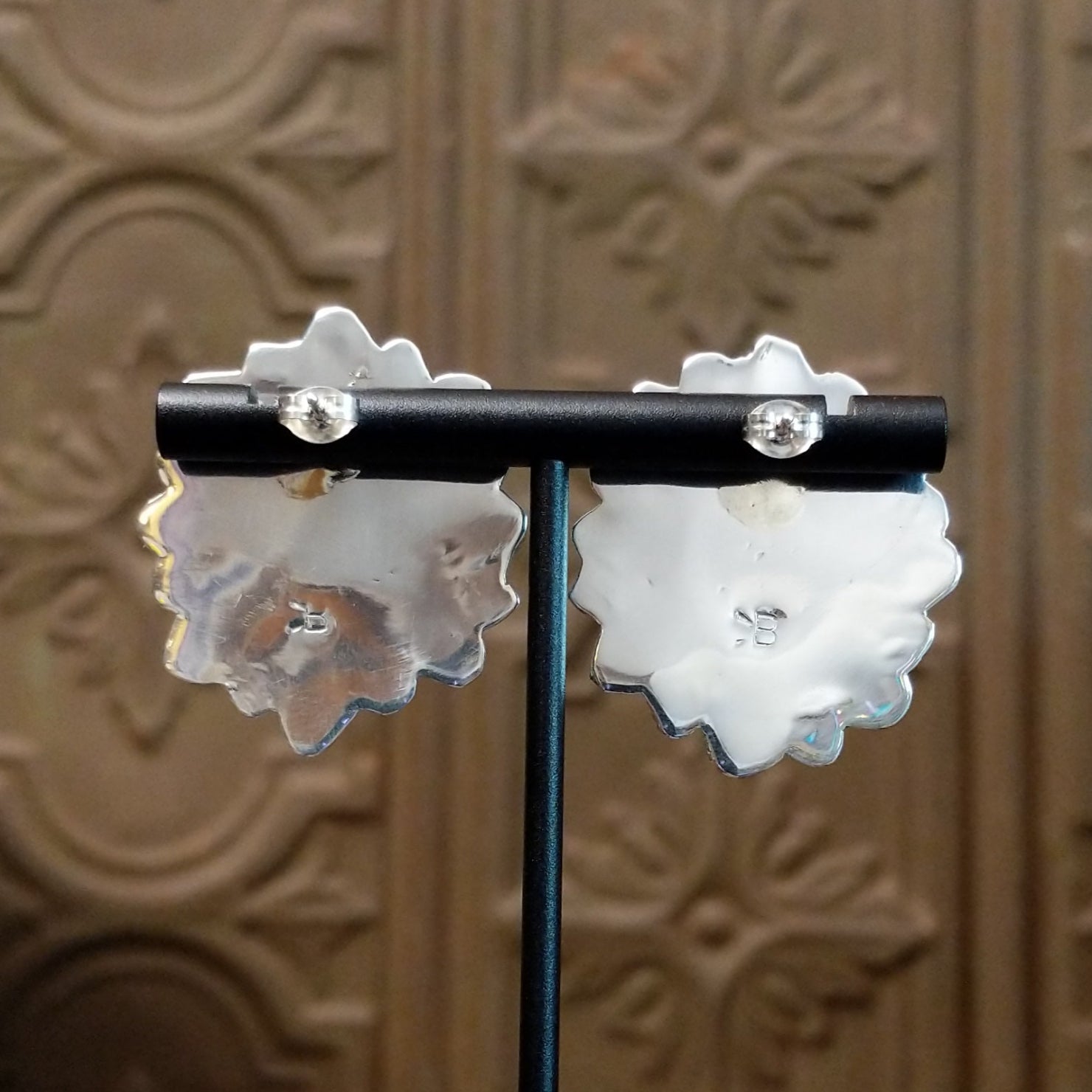 The rear of the earrings reveals a polished sterling silver backing with a secure post.
