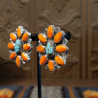 The partial side angle displays the turquoise stone and orange spiny oyster shell on the bezel of the earrings.