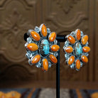 The partial side angle displays the turquoise stone and orange spiny oyster shell on the bezel of the earrings.