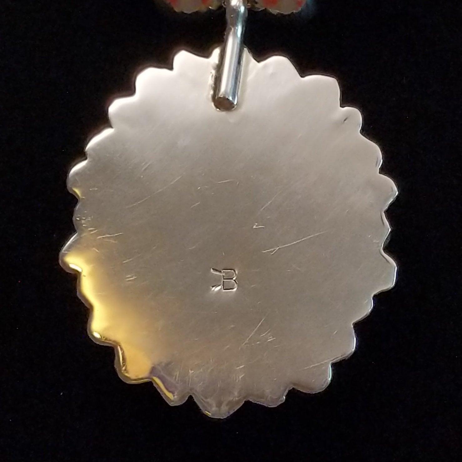 The stamped signature is on the sterling silver of the necklace pendants and earrings.