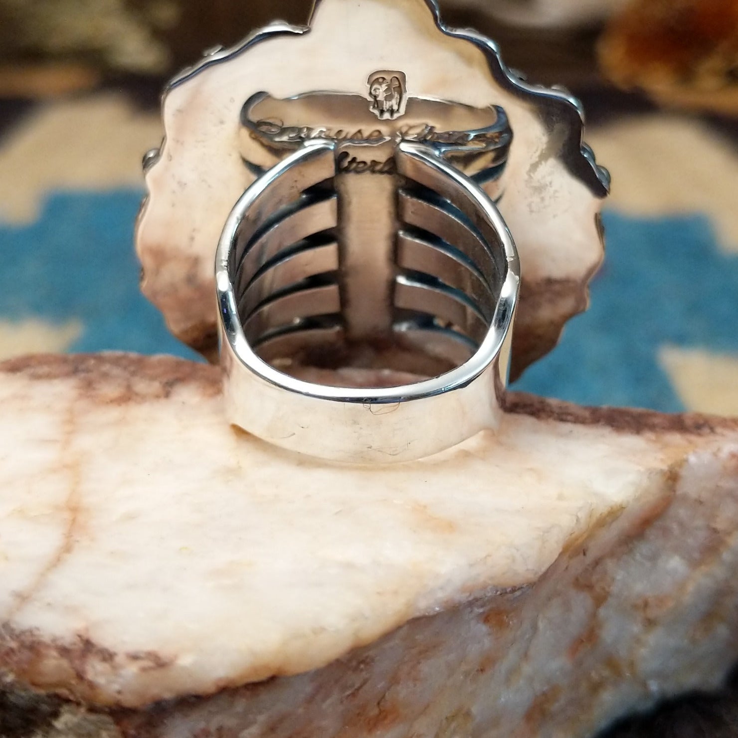 Sterling silver ring with orange spiny oyster shell set in the bezel, framed by ornate silverwork.