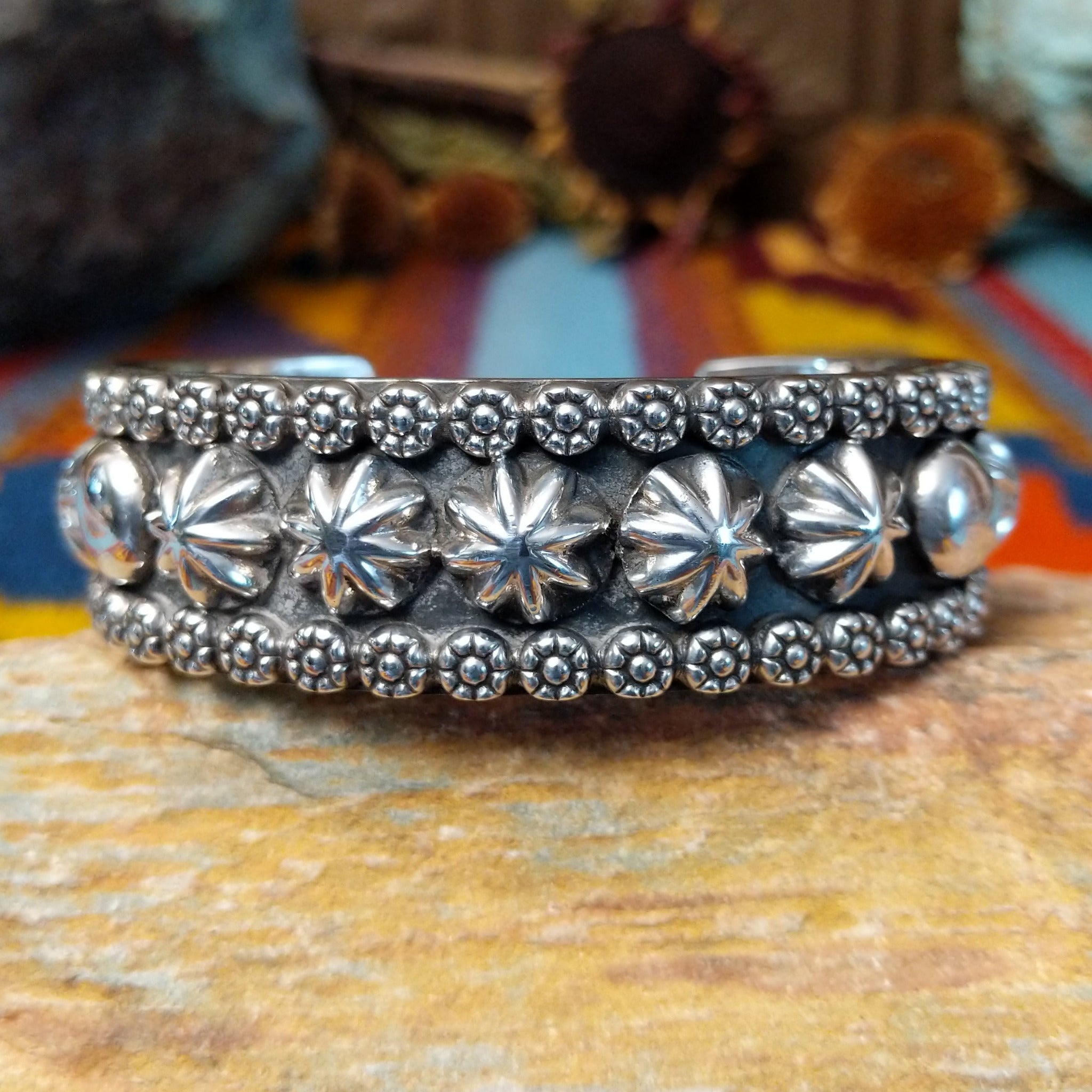 Wide silver cuff by Marc Antia with raised silver ornaments, fluted details, and beaded borders.