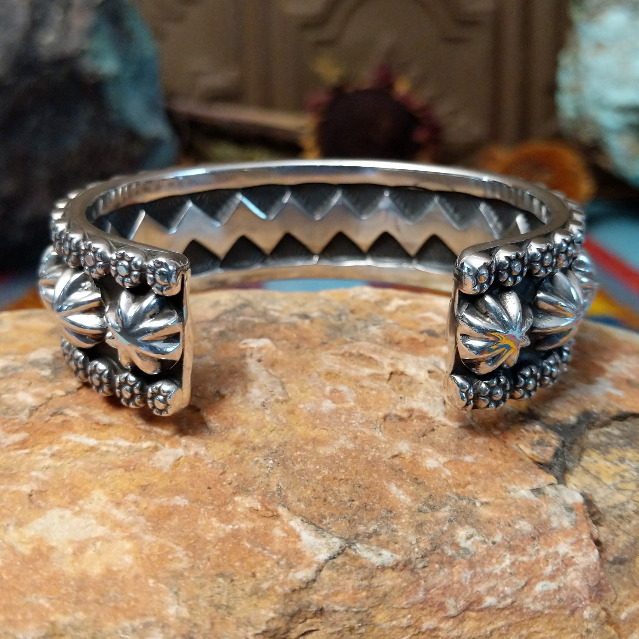 Wide silver cuff by Marc Antia with raised silver ornaments, fluted details, and beaded borders.
