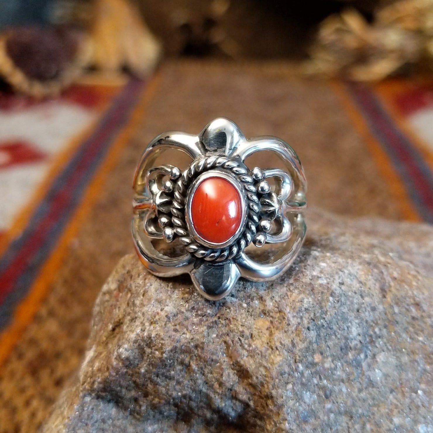 Sterling silver ring with ornate silver work and coral set in the round bezel.