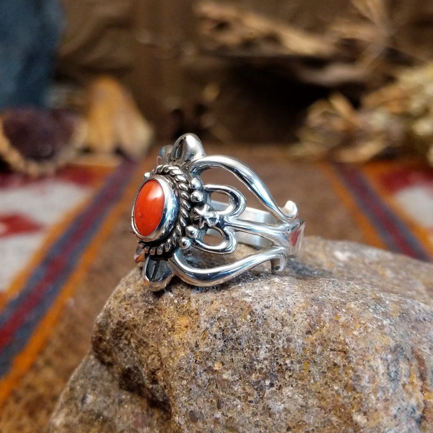Sterling silver ring with ornate silver work and coral set in the round bezel.