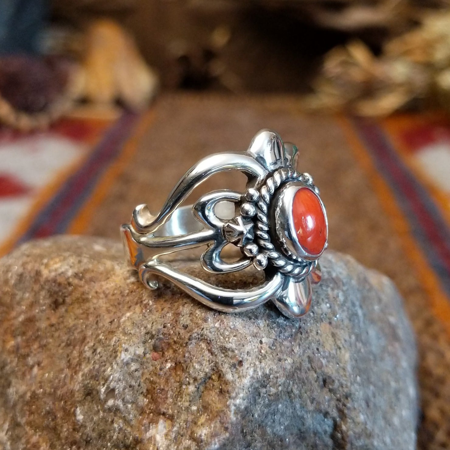 Sterling silver ring with ornate silver work and coral set in the round bezel.