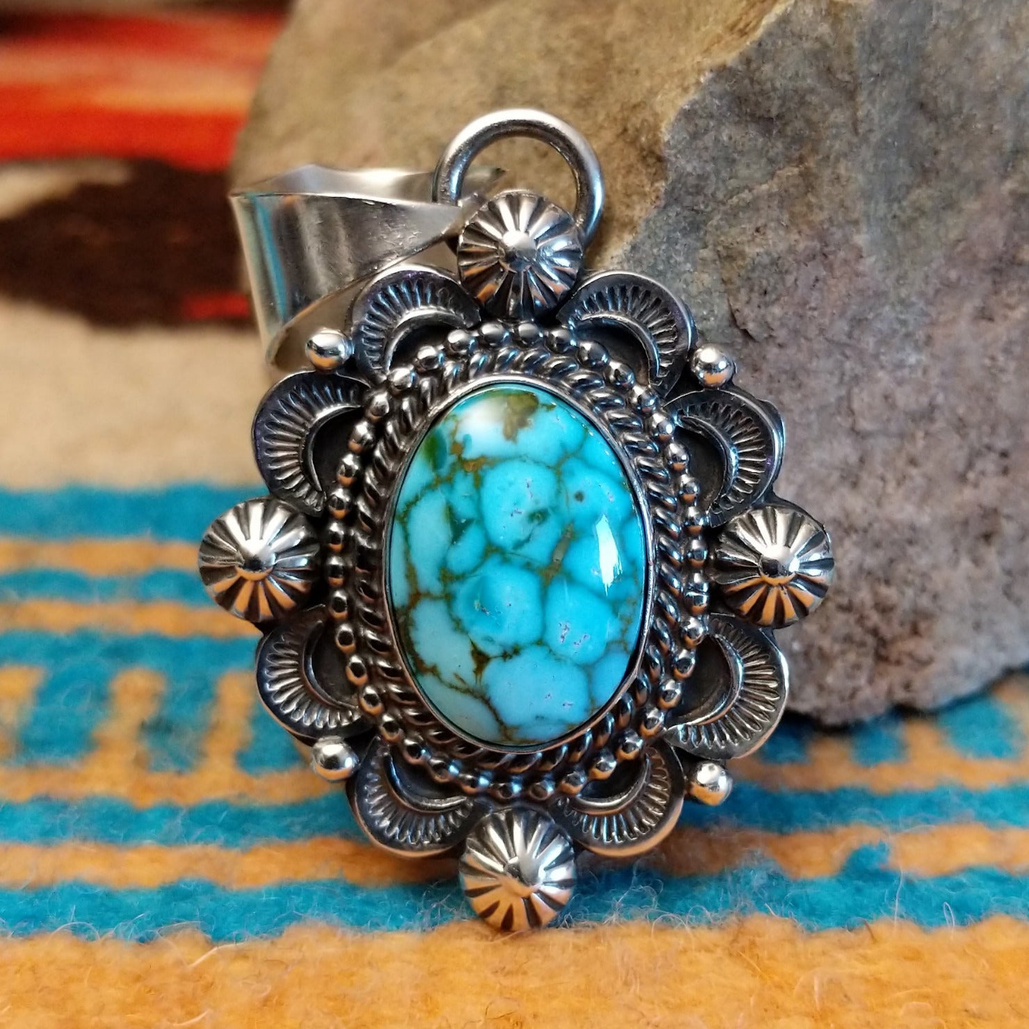 Sterling silver pendant with Kingman turquoise set in the oval bezel, framed by the ornate setting with twisted rope and dotted accents.