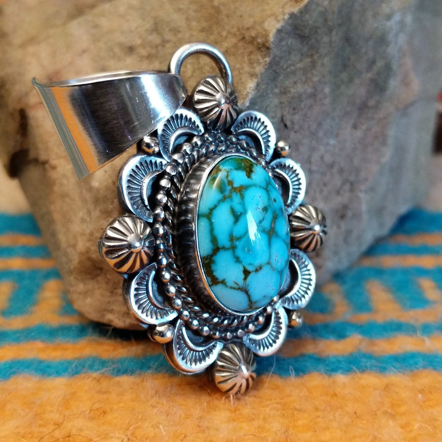 Sterling silver pendant with Kingman turquoise set in the oval bezel, framed by the ornate setting with twisted rope and dotted accents.