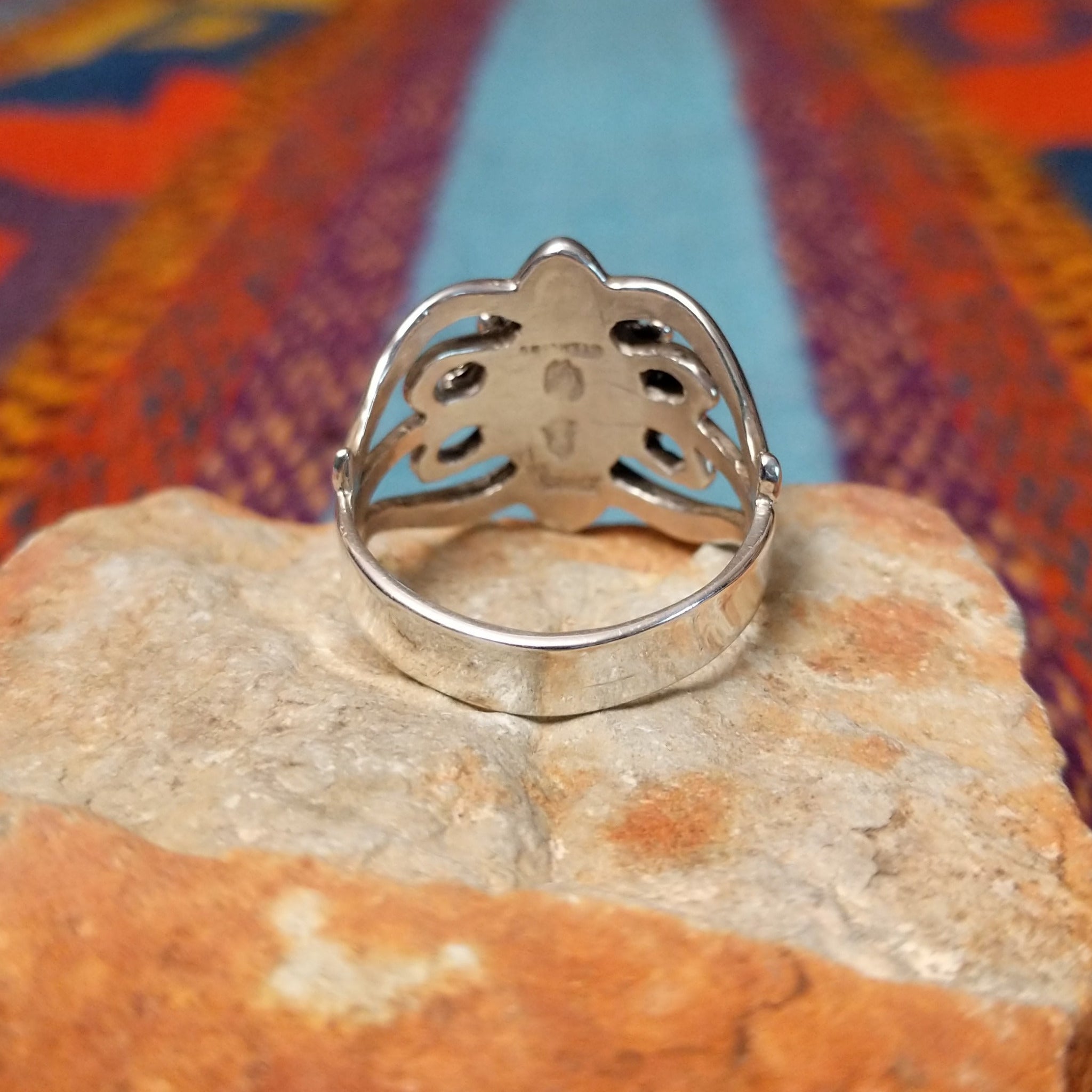 Ornate Lapis Ring by Raymond Coriz featuring an oval blue lapis stone set in Sterling Silver with twisted rope, polished bead accents, sculpted details, and decorative openwork; underside view.