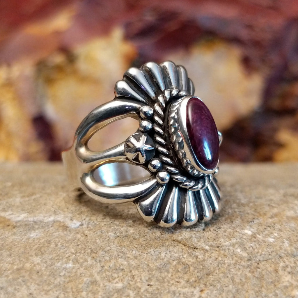 Purple spiny oyster shell framed by a twisted rope accent and fan-like designs.