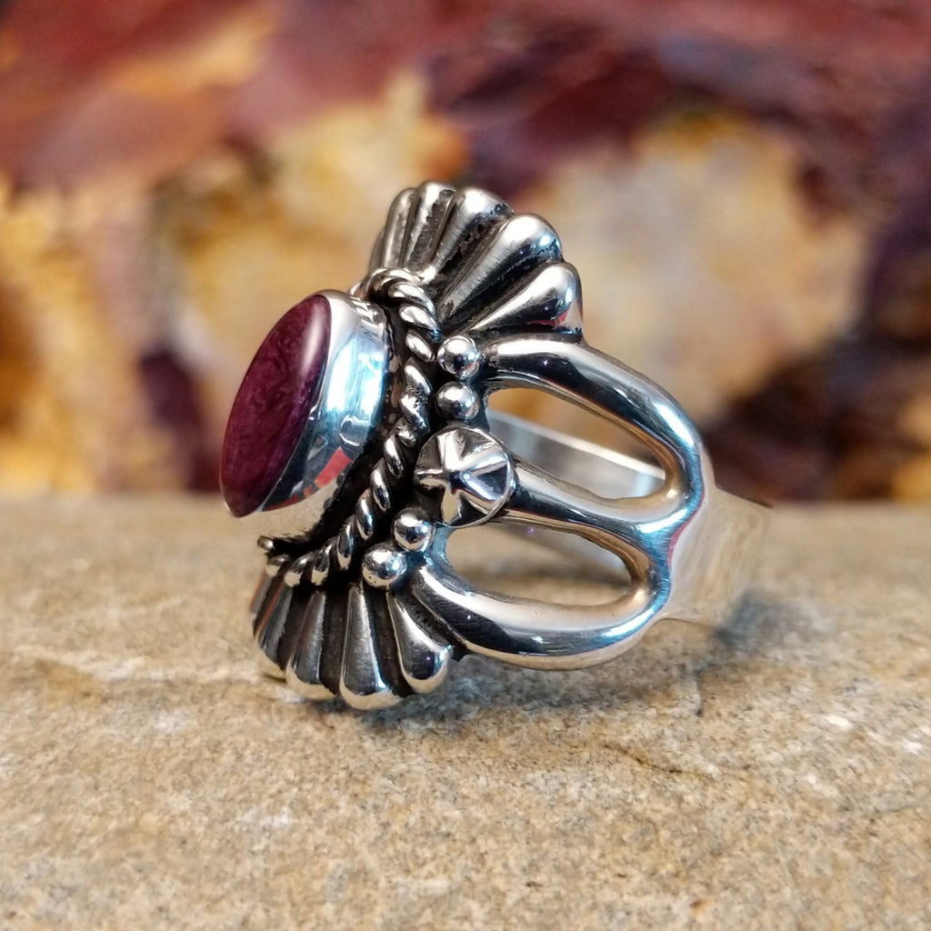 Purple spiny oyster shell framed by a twisted rope accent and fan-like designs.