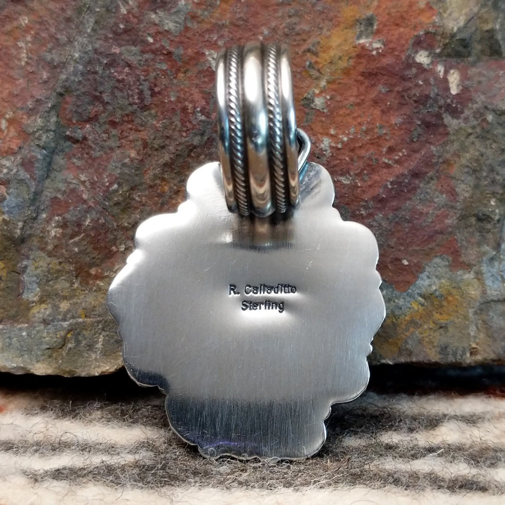The back of the pendant features the artisan's signature.
