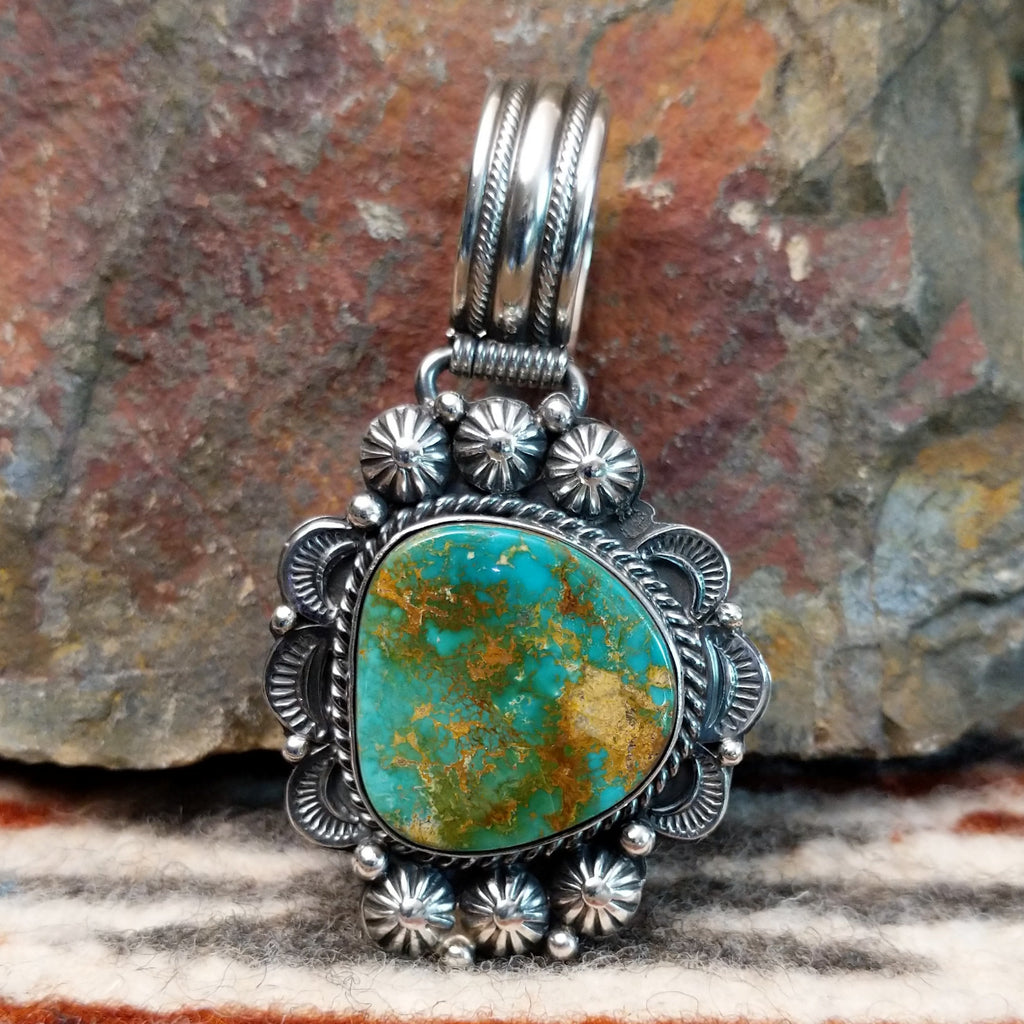 Sterling silver pendant with ornate detailing and royston turquoise centerpiece.