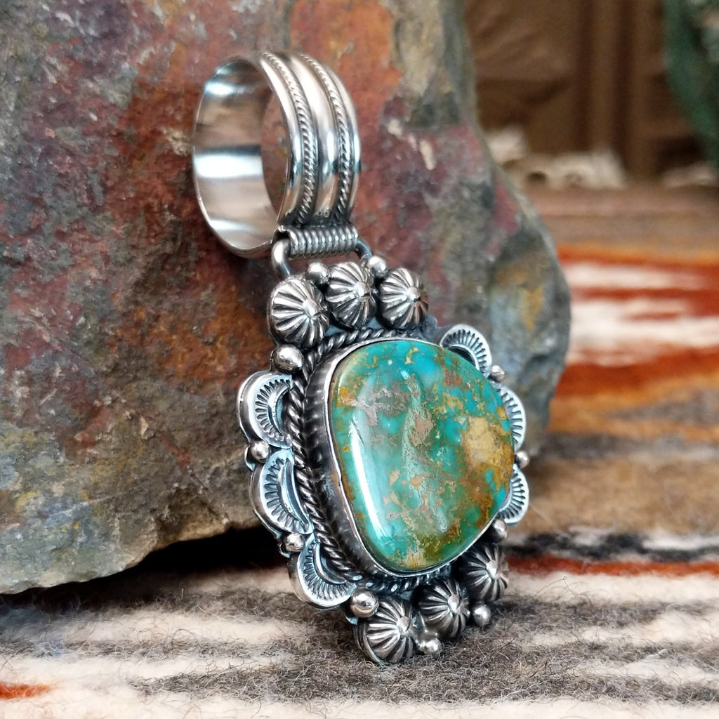 Sterling silver pendant with ornate detailing and royston turquoise centerpiece.