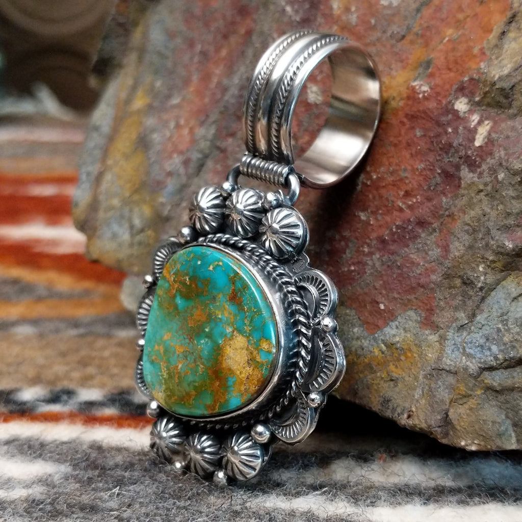 Sterling silver pendant with ornate detailing and royston turquoise centerpiece.