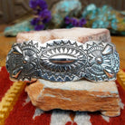 Sterling silver barrette by Harold Tom with ornate stamped silverwork and raised oval center.