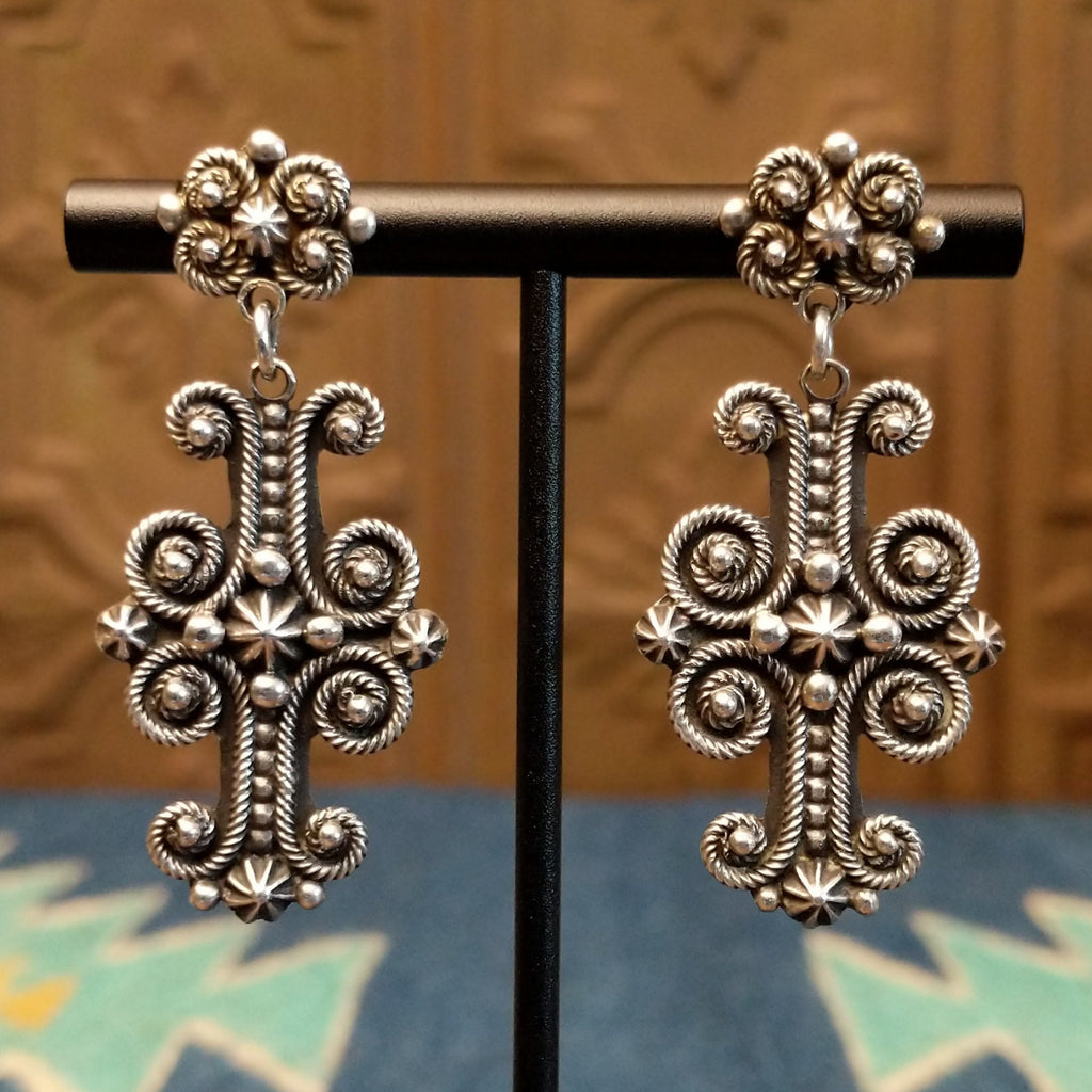 Ornate sterling silver cross earrings with floral detailing and dot work.