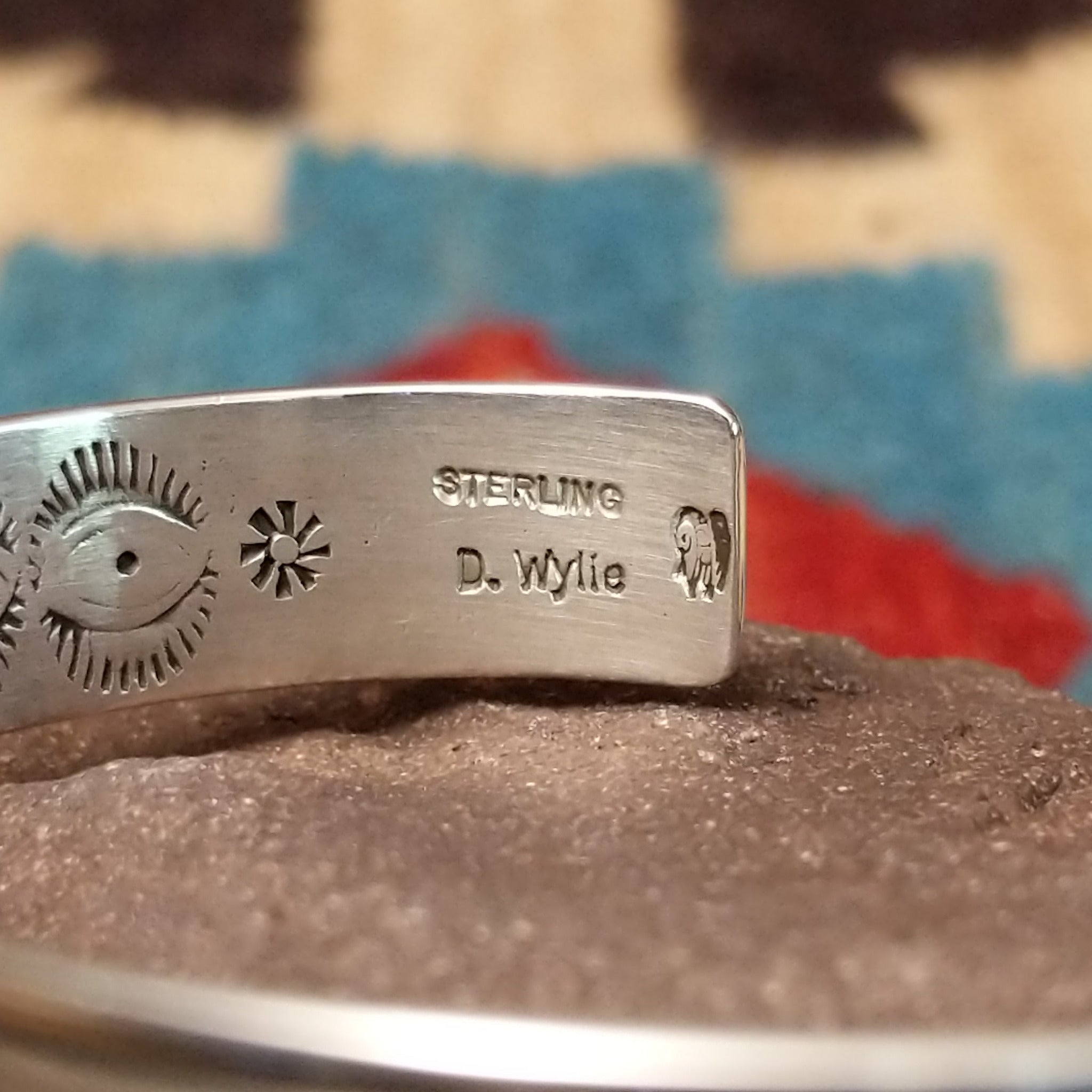 Ornate stamped sterling silver cuff by Diane Wylie, featuring intricate geometric hand-stamped patterns framed by polished silver borders in a handcrafted open cuff design.  Artisan and Sterling Silver stamp.