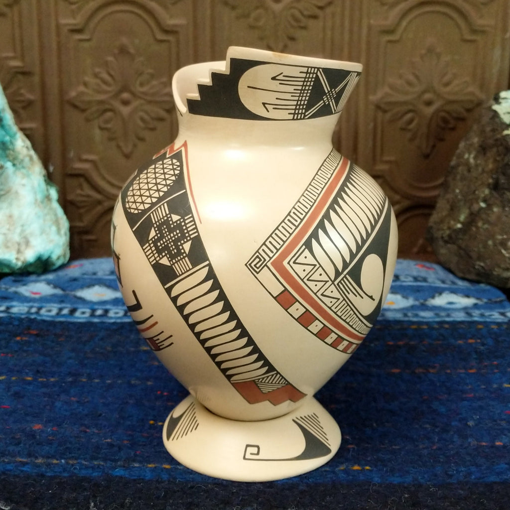 White clay body with black and red ornate stepped patterns and lattice work.
