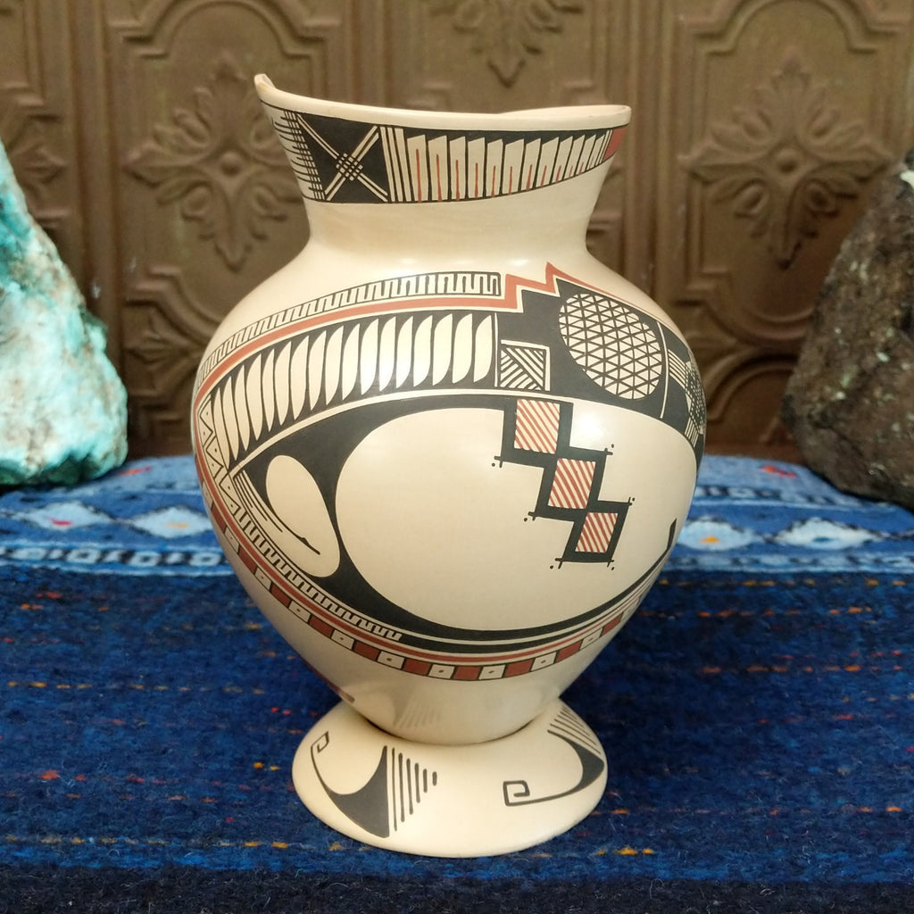 White clay body with black and red ornate stepped patterns and lattice work.