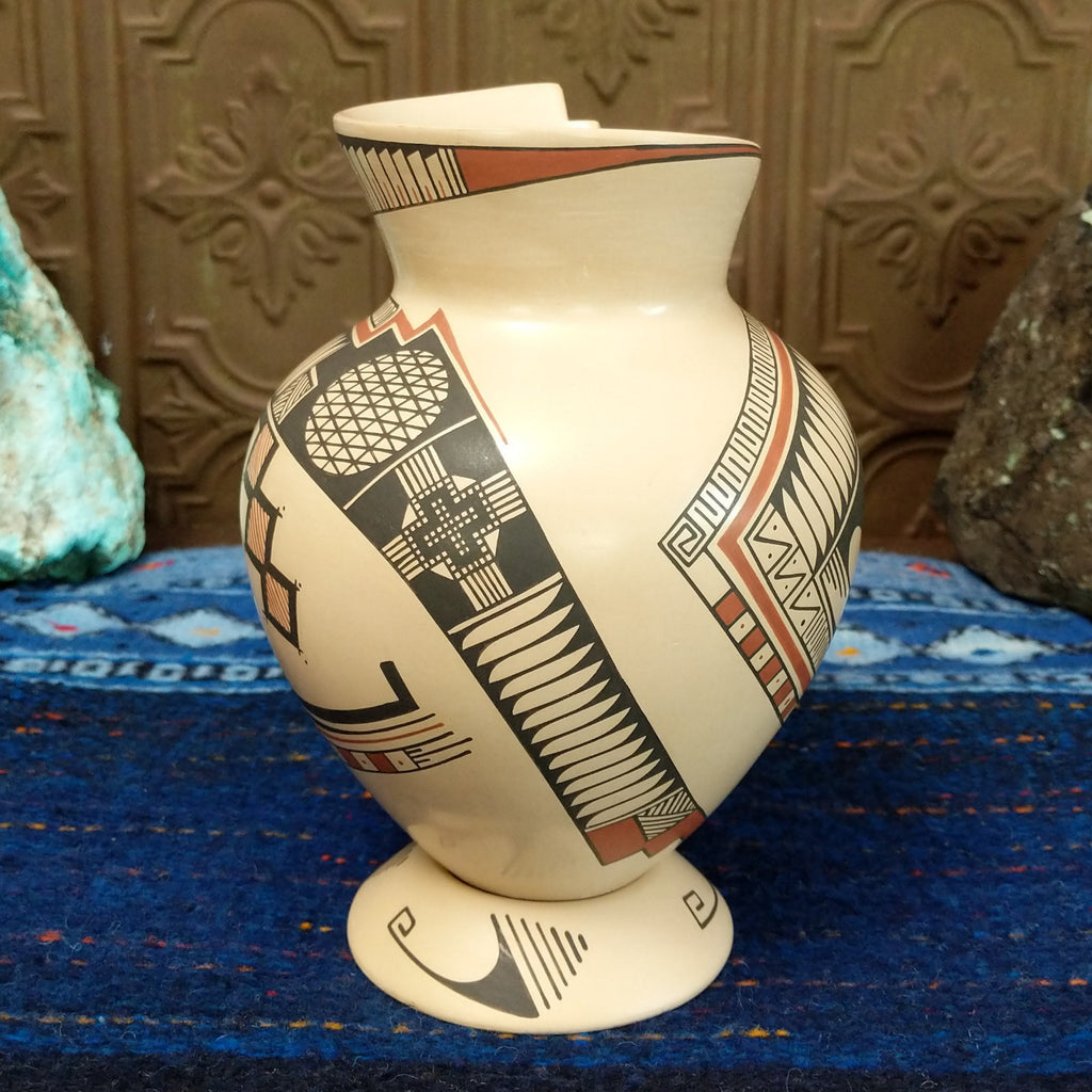 White clay body with black and red ornate stepped patterns and lattice work.