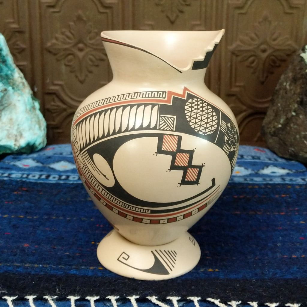 White clay body with black and red ornate stepped patterns and lattice work.