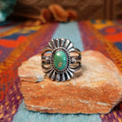 Ornate Turquoise Ring by Raymond Coriz with oval turquoise stone, fluted silverwork, and split band.