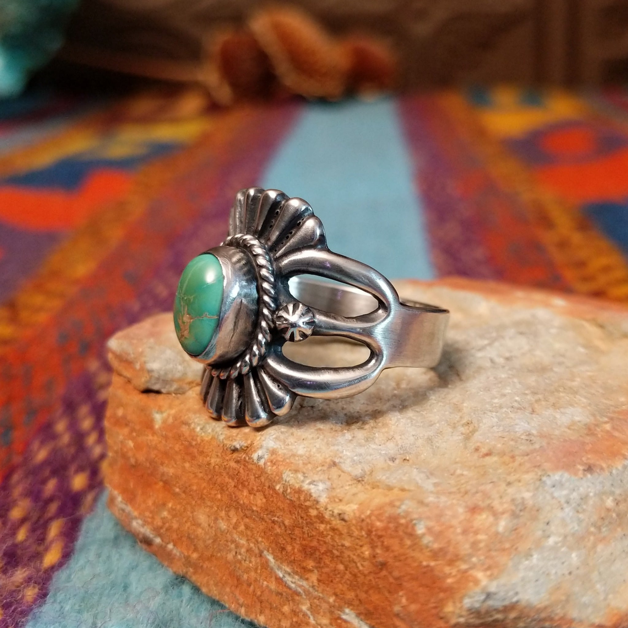 Ornate Turquoise Ring by Raymond Coriz with oval turquoise stone, fluted silverwork, and split band.