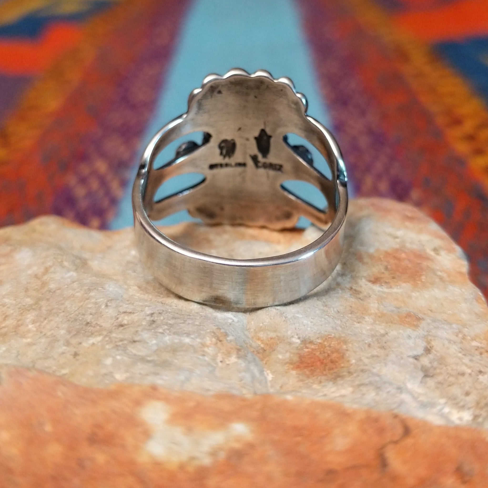 Ornate Turquoise Ring by Raymond Coriz with oval turquoise stone, fluted silverwork, and split band.