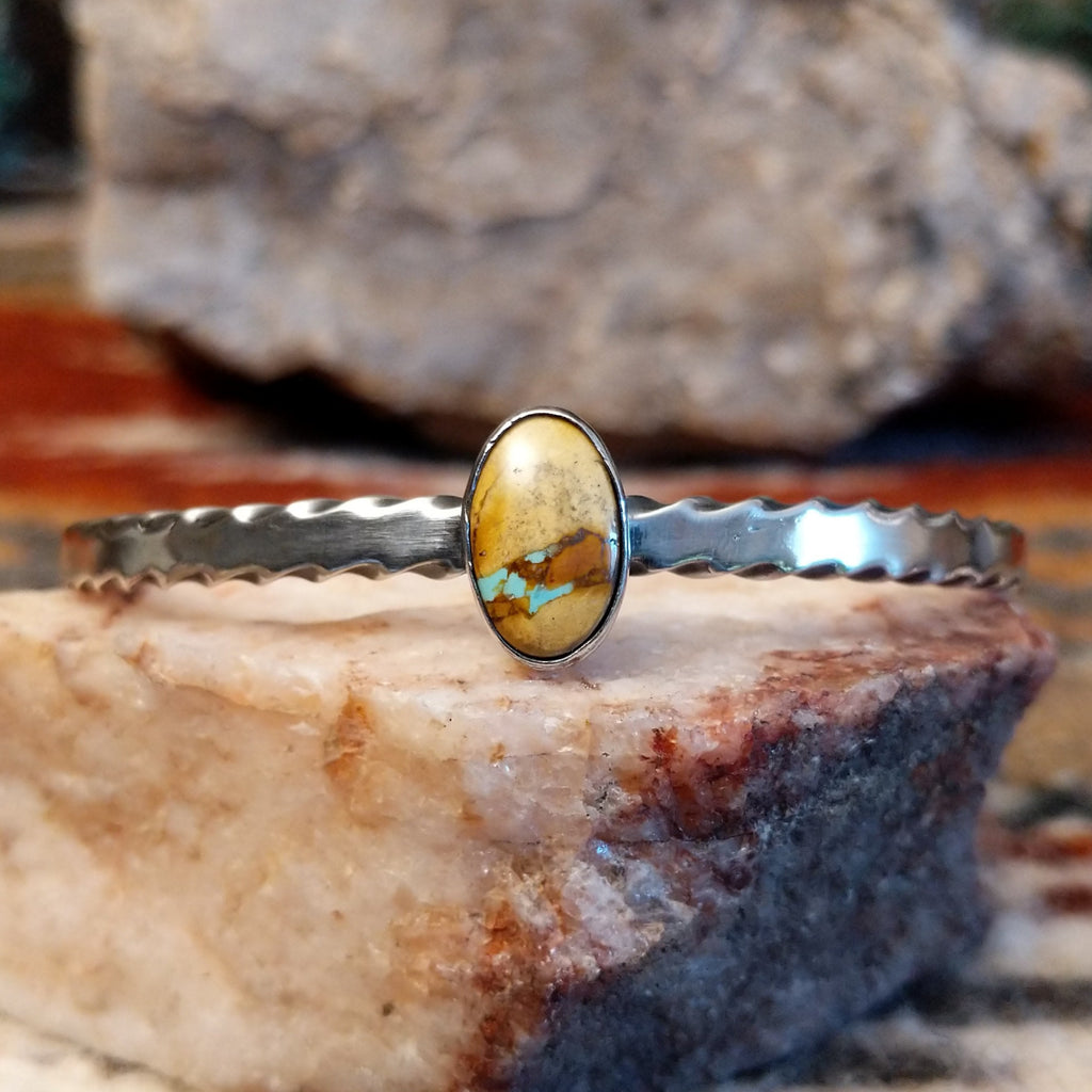 Oval boulder turquoise set in the bezel with a brushed sterling silver band of the cuff.