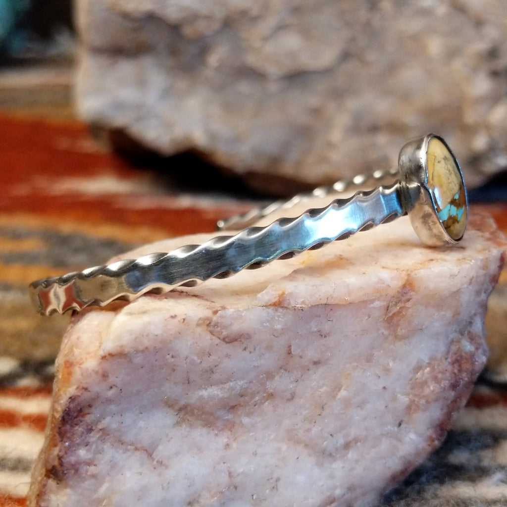 Oval boulder turquoise set in the bezel with a brushed sterling silver band of the cuff.