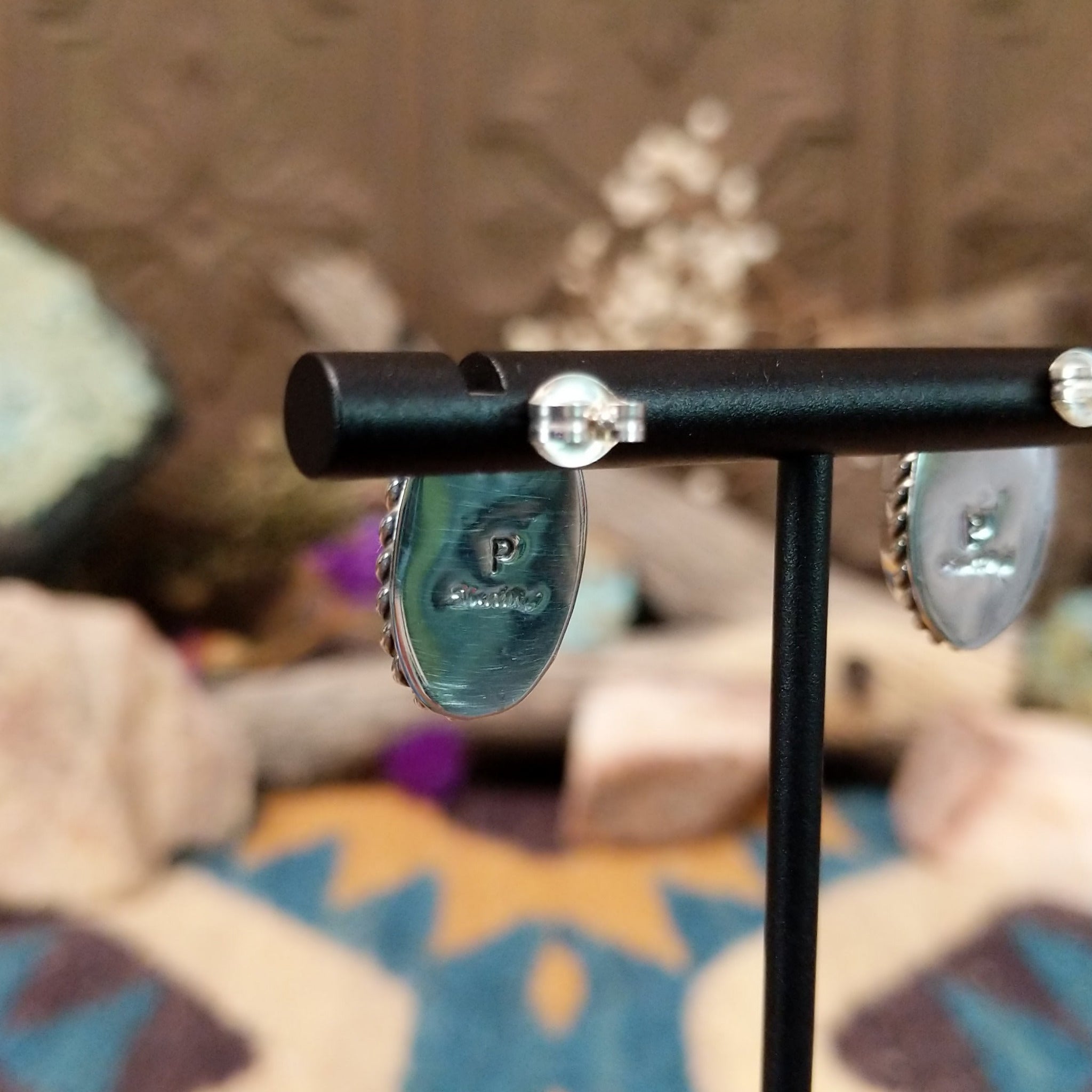 Handcrafted sterling silver post earrings by Priscilla Smith featuring oval charoite cabochons in polished bezel settings with traditional twisted rope border detailing; artisan and Sterling Silver stamp.