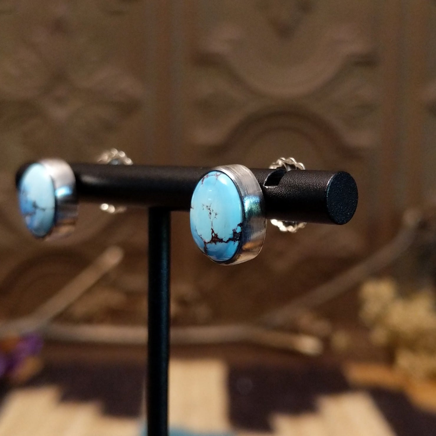 Sterling silver earrings with turquoise set in oval bezels.