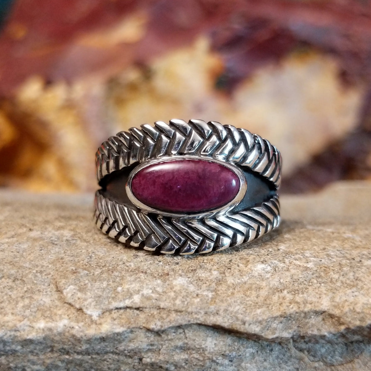 Oval purple spiny oyster shell set in a silver bezel with a braided sterling silver band.