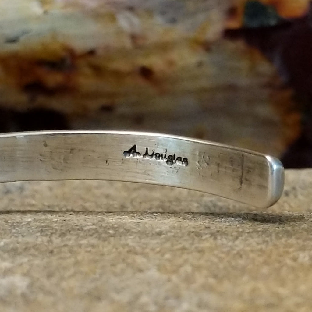 The artist's signature is stamped into the underside of the band.