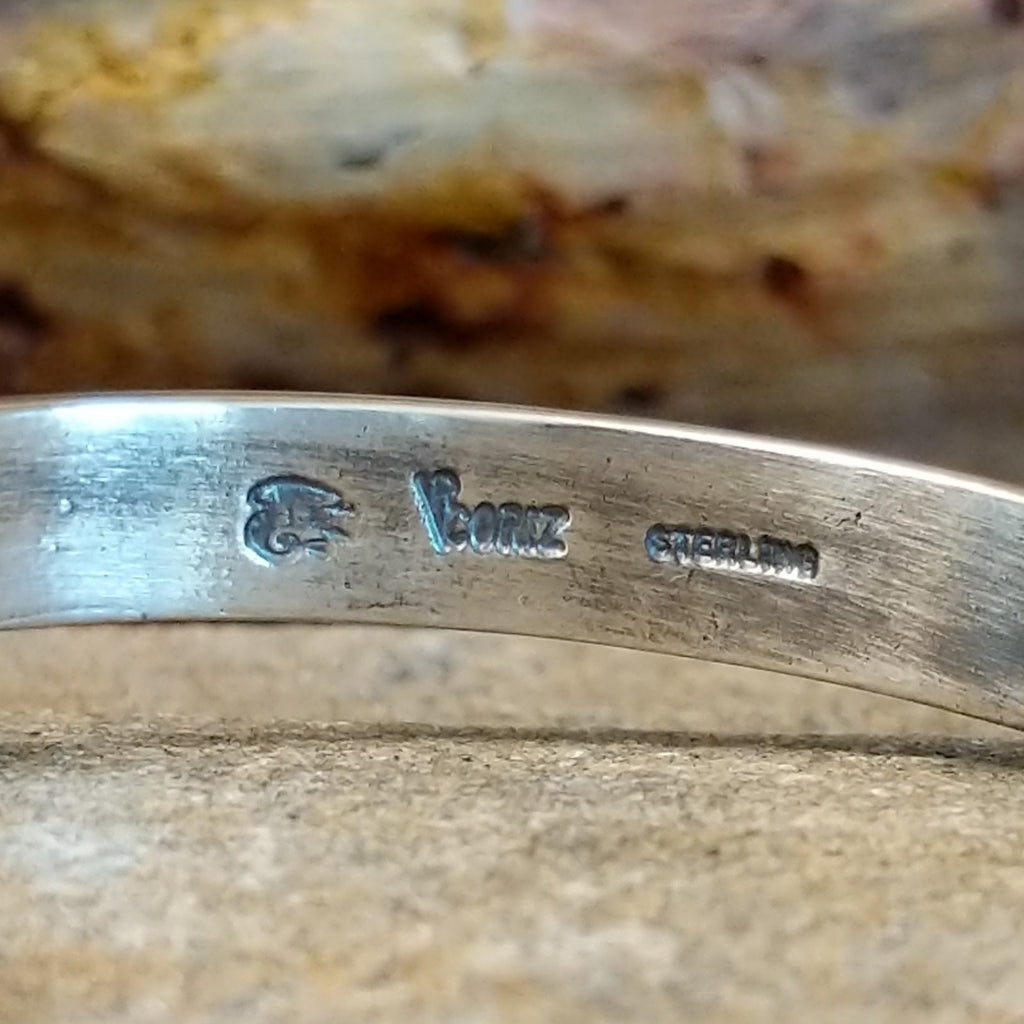 The artist's signature is etched on the inside of the band.