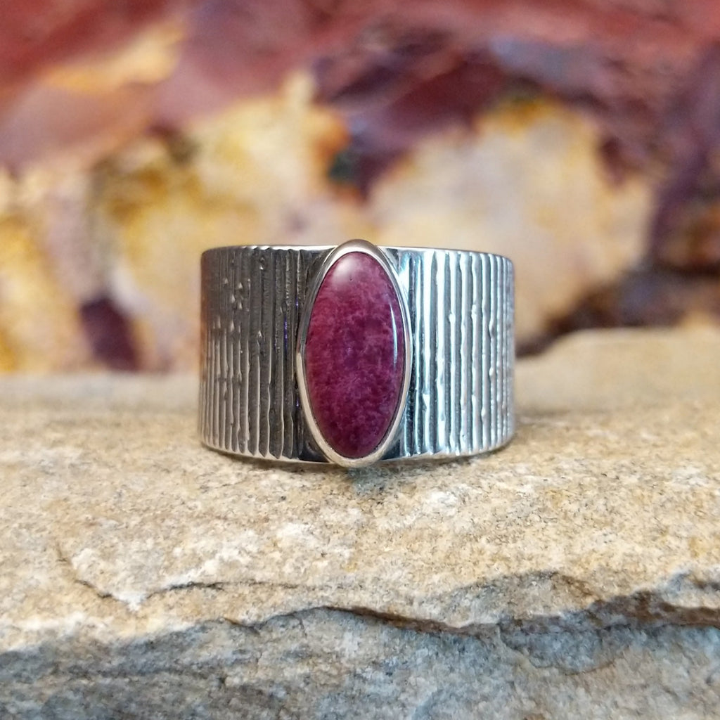 Oval purple spiny oyster shell set in a raised bezel with a lined sterling silver band.